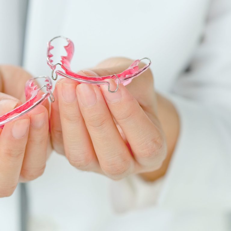 dentist-holding-retainer-2025-03-10-15-42-50-utc